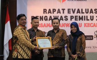 Ketua Bawaslu Kota Semarang Arief Rahman saat menyerahkan piagam penghargaan kepada salah satu pemenang penghargaan